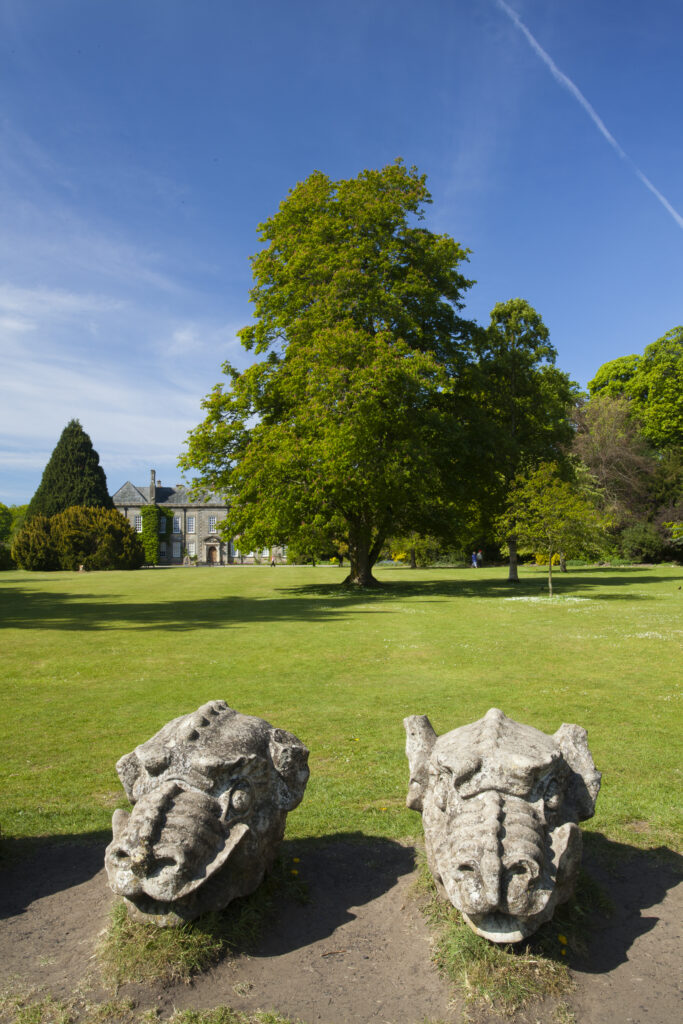 England. Northumberland, Wallington Hall. Carved stone dragon heads in the gardens of Wallington Hall, a National Trust property located in the north of England.