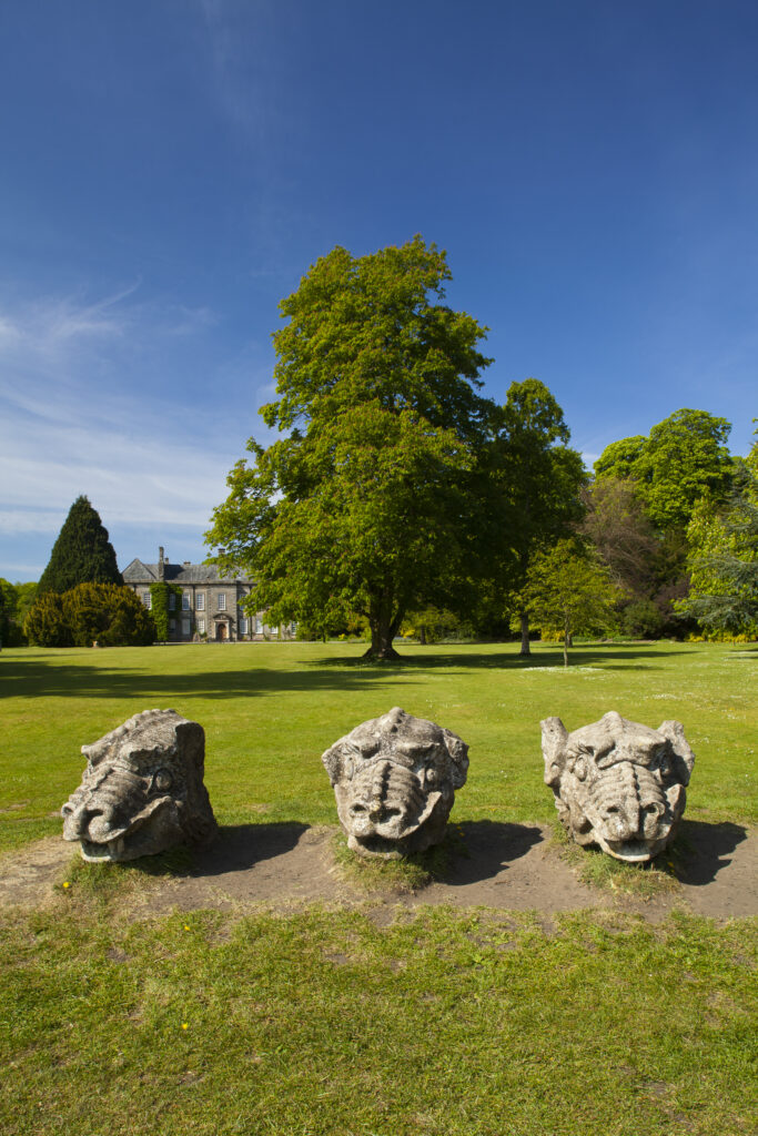 England. Northumberland, Wallington Hall. Carved stone dragon heads in the gardens of Wallington Hall, a National Trust property located in the north of England.