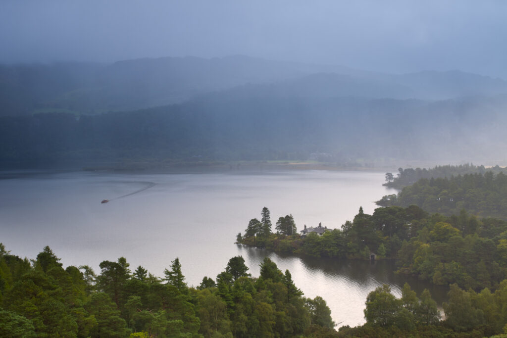 England, Cumbria, Lake District National Park. Rain clears from Derwentwater, a lake near the town of Keswick, viewed from above Manesty Park.