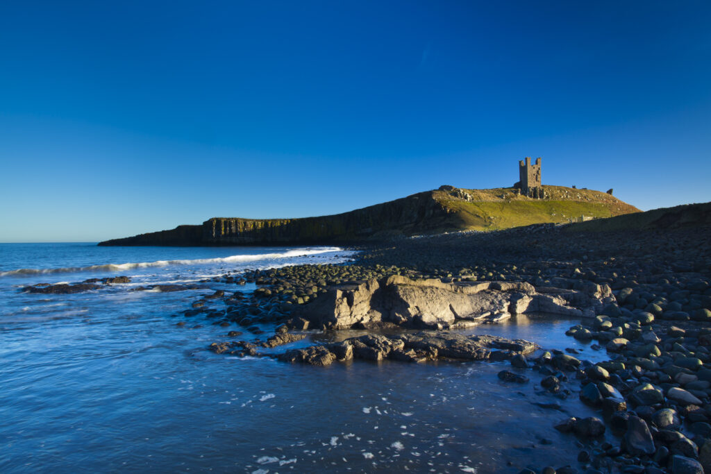 England, Northumberland, Embleton Bay. The Lilburn Tower, part of the remains of Dunstanburgh Castle, viewed from Embleton Bay.