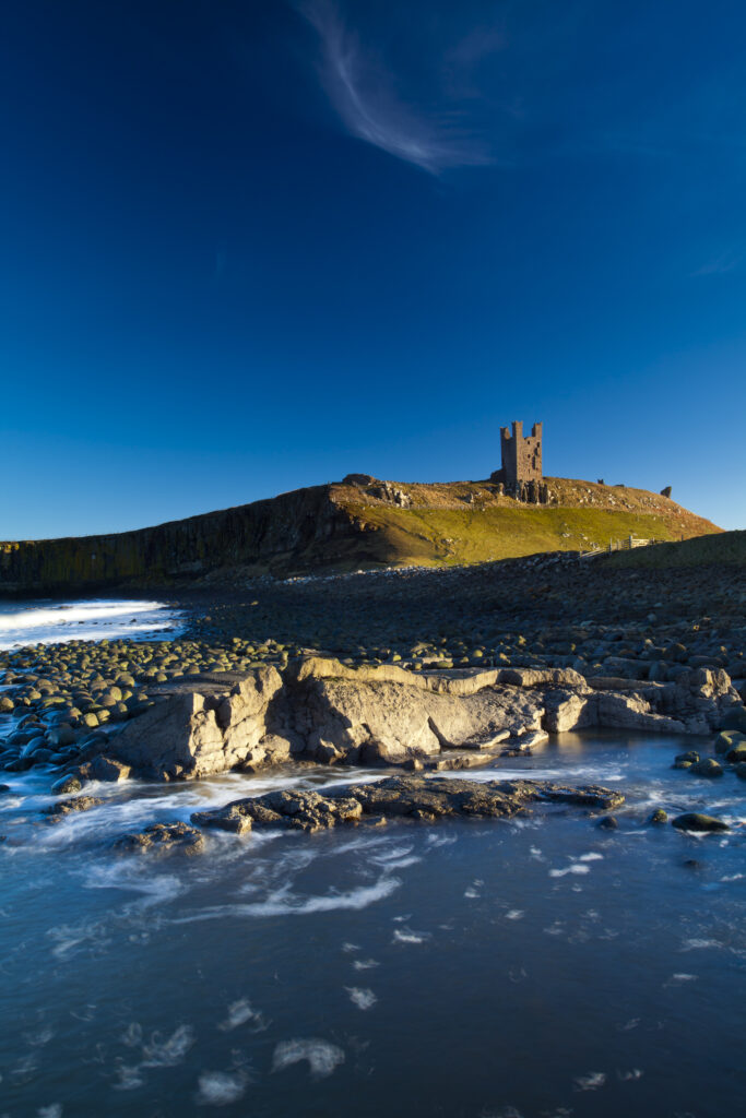 England, Northumberland, Embleton Bay. The Lilburn Tower, part of the remains of Dunstanburgh Castle, viewed from Embleton Bay.