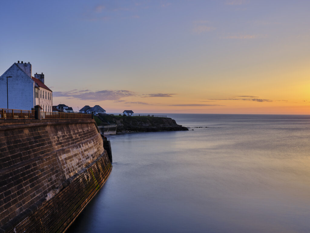 England, Tyne and Wear, Cullercoats. Sunrise over Cullercoats Bay.