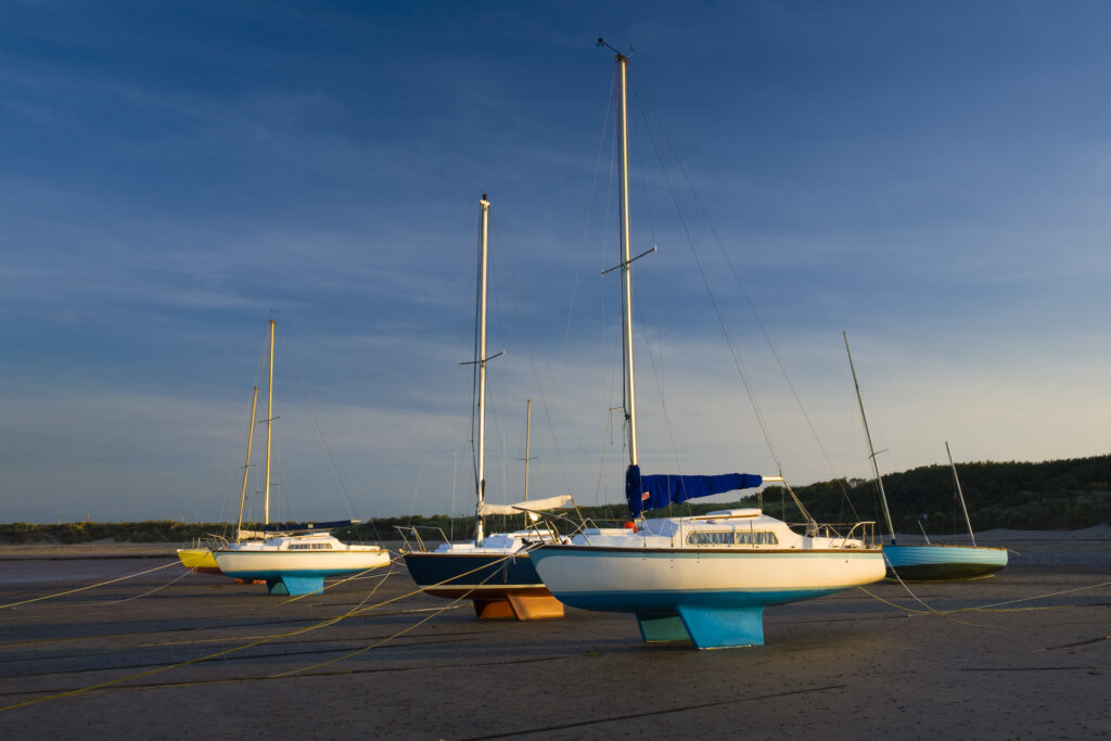 England, Northumberland, Beadnell. Small sailing boats moored in Beadnell Bay - viewed at low tide.