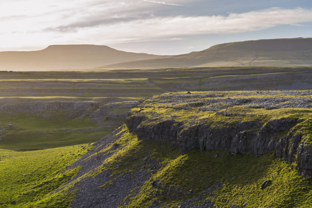England, North Yorkshire, Yorkshire Dales National Park. Looking towards the peak of Ingleborough and the Moughton Scars, a natural karst landform (limestone pavement) which is common in the Yorkshire Dales.