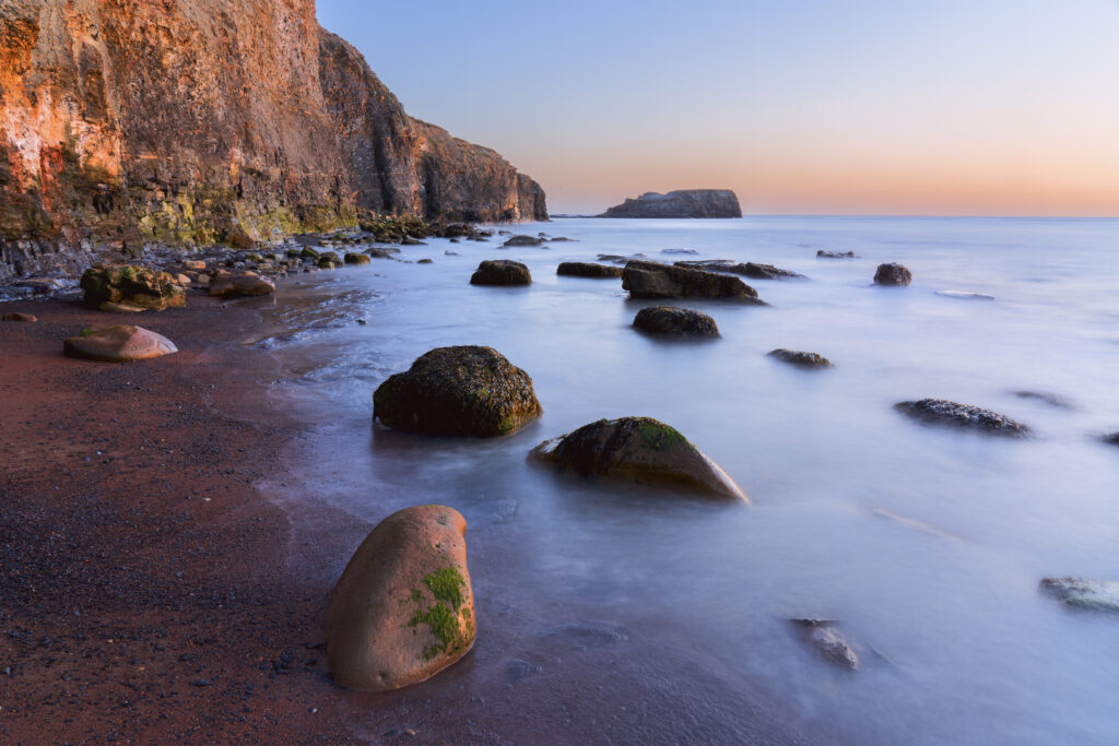 England, North Yorkshire, North York Moors National Park. Early morning light at Saltwick Bay and Nab near Whitby.