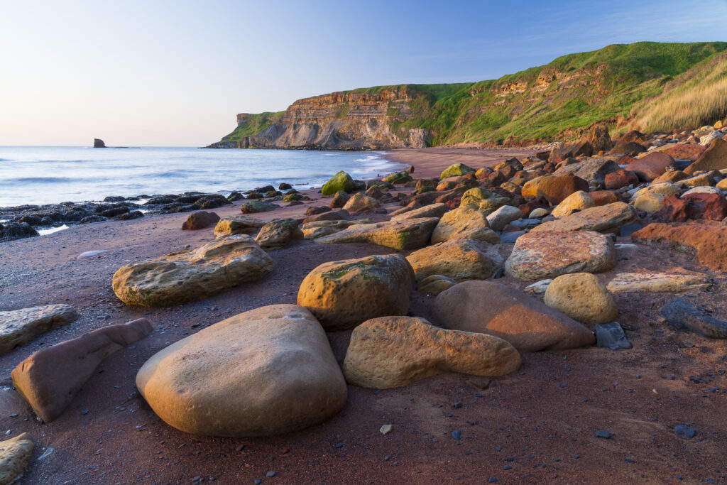 England, North Yorkshire, North York Moors National Park. Early morning light at Saltwick Bay and Nab near Whitby.