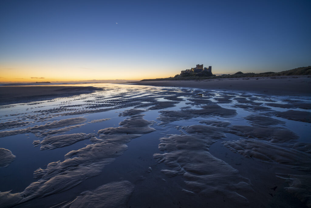 England, Northumberland, Bamburgh. Pre-dawn colours on the Northumberland Heritage Coast overlooked by Bamburgh Castle.