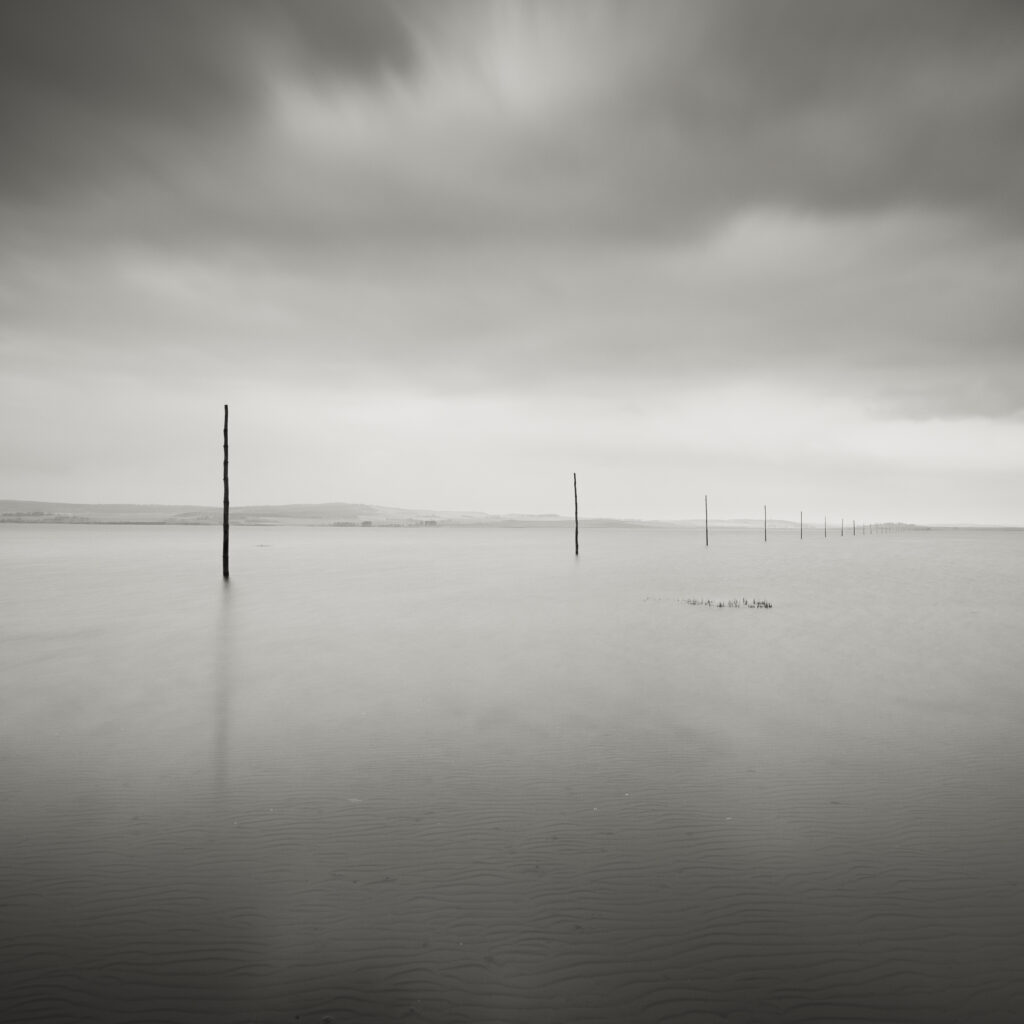 England, Northumberland, Northumberland Heritage Coast. Wooden posts marking the Pilgrim's Causeway linking the Holy Island of Lindisfarne off the Northumberland Coast with the mainland.