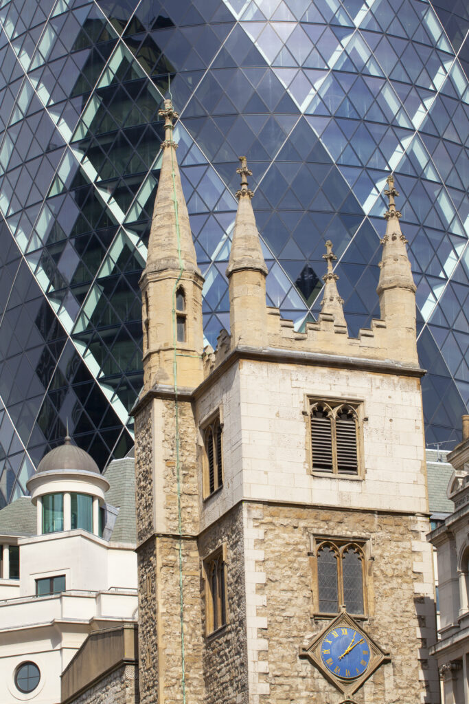 England, Greater London, The City of London. The contrasting architecture of the St Andrew Undershaft Church against a backdrop of the famous Gherkin building.