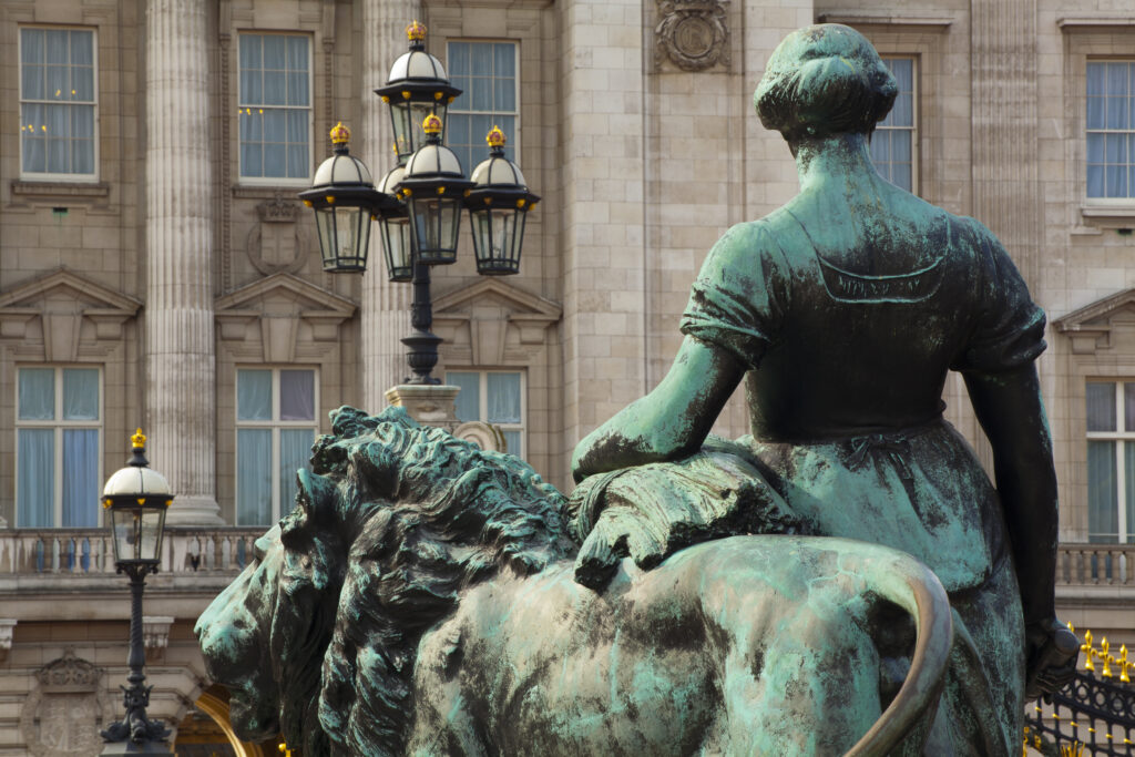 England, Greater London, City of Westminster. Bronze statue on the Victoria Memorial in Queen's Garden, looking towards Buckingham Palace in the distance.