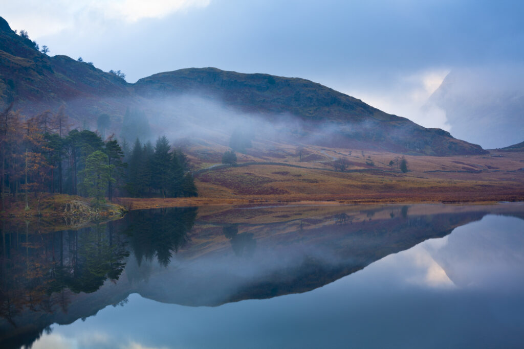 England, Cumbria, The Lake District. A misty dawn at Blea Tarn near Great Langdale.