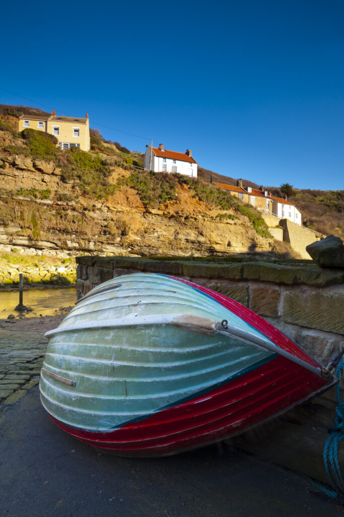 England, North Yorkshire, Staithes. Fishing boat moored near to a river in the old town of Staithes, located within the North York Moors National Park.