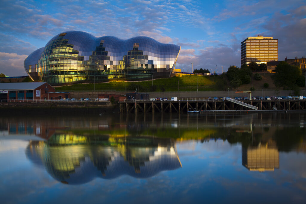 England, Tyne & Wear, Gateshead. The Sage gateshead building reflected in the River Tyne, viewed from the Newcastle Upon Tyne quayside