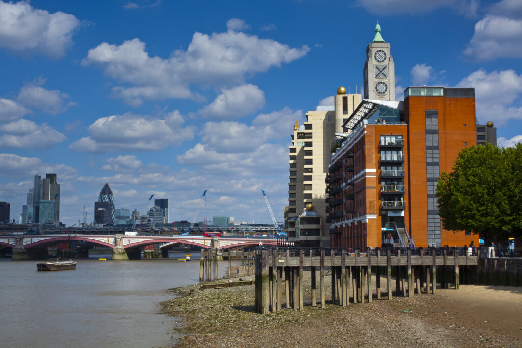 England, London, OXO Tower. The OXO Tower viewed from upstream of the River Thames, with Sea Containers House and the City Of London and Gherkin building beyond.