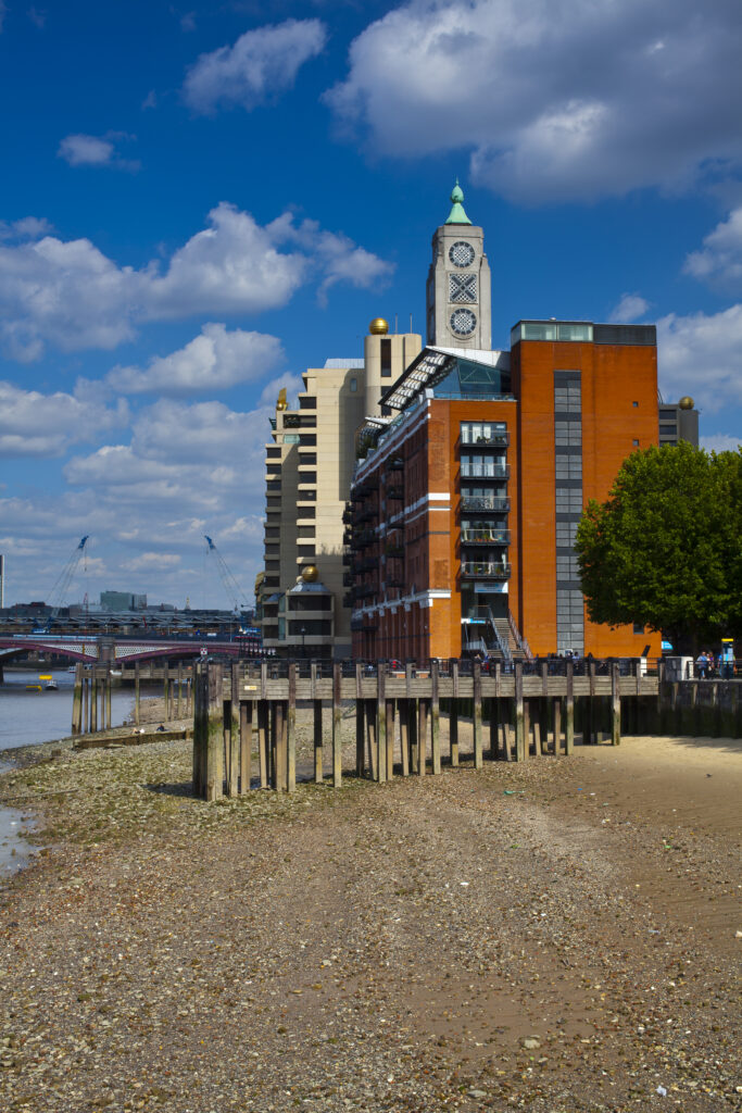 England, London, OXO Tower. The OXO Tower viewed from upstream of the River Thames, with Sea Containers House and the City Of London and Gherkin building beyond.