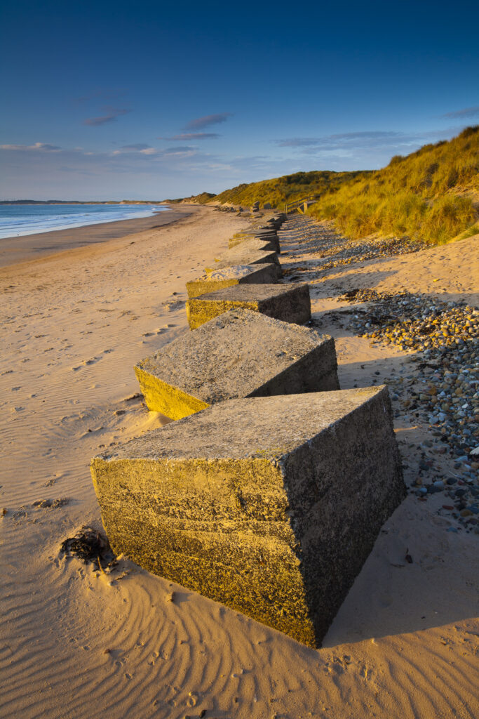 England, Northumberland, Druridge Bay. World War Two anti-tank blocks defending the picturesque beach at Druridge Bay.