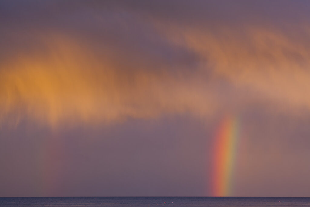 Scotland, Scottish Borders, Burnmouth. Rainbow above the north sea, photographed just before sunset.