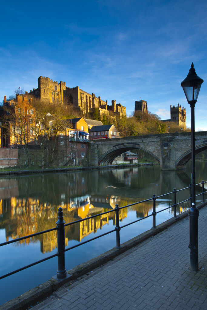 England, County Durham, Durham City. Bridge over the River Wear in the city of Durham, with Durham Castle, Cathedral and city reflected upon the still water face.