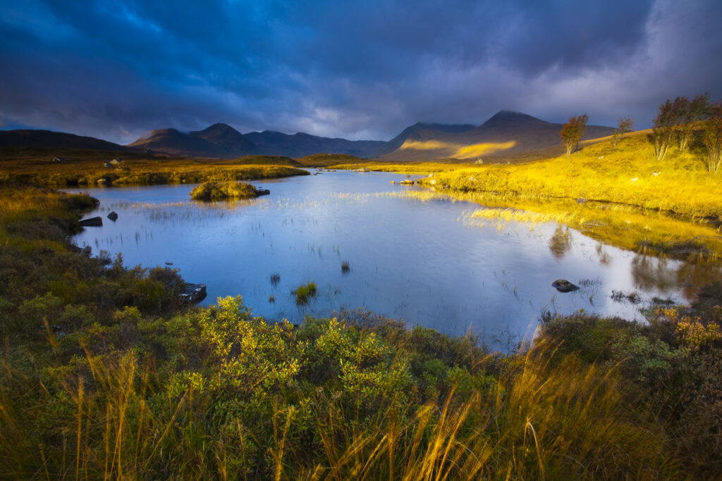 Scotland, Scottish Highlands, Rannoch Moor. Lochan an Stainge located on Rannoch Moor with the dominating peak of the Black Mount and surrounding mountains in the distance.