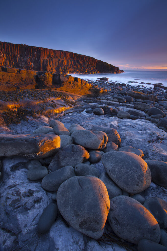 England, Northumberland, Cullernose Point. Dawn light illuminates the rocky shoreline of Cullernose Point, near the village of Craster on the Northumberland Heritage Coast.