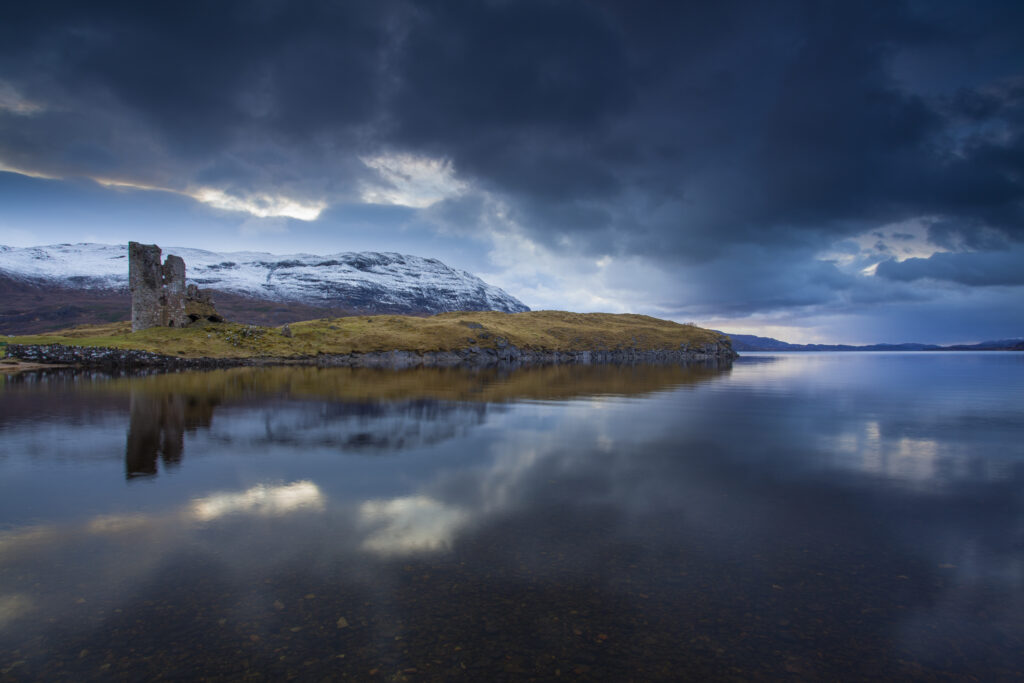 Scotland, Scottish Highlands, Assynt. The dramatic ruins of Ardvreck Castle located on a rocky promontory that juts into Loch Assynt. The castle was constructed by the MacLeods of Assynt during two phases in 1500 and 1590.