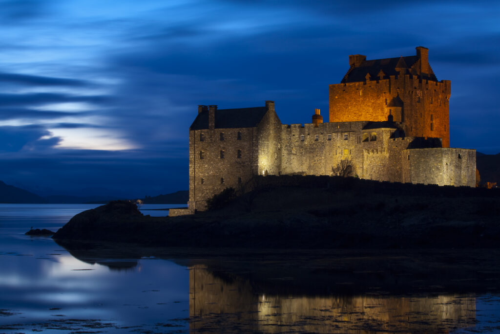Scotland, Scottish Highlands, Eilean Donan Castle. Eilean Donan Castle reflected in the still waters of Loch Duich at dusk.