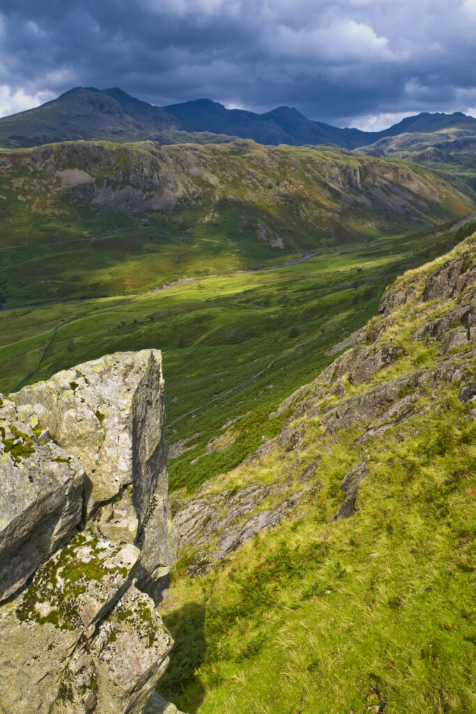 England, Cumbria, Lake District National Park. Looking along the route of the River Esk from the Hardknott Castle Roman Fort, as storms clouds gather above the countrys’ highest peak, Scafell Pike at 3205ft.