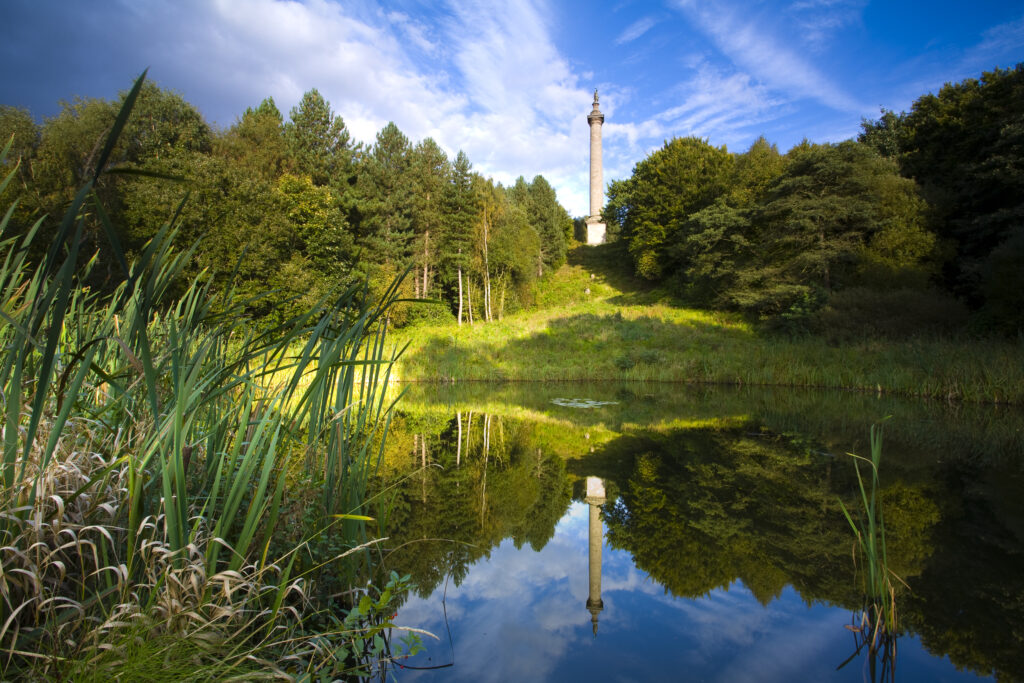 England, Tyne and Wear, Gibside. The column of liberty reflected in a pool forming part of the 18th-century landscaped 'forest' garden.