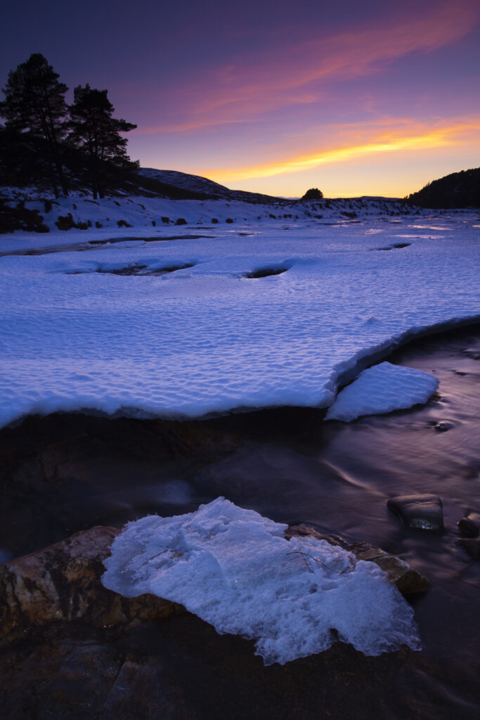 Scotland, Aberdeenshire, Linn of Dee. Pink sunset over the ice covered River Dee near the bridge over the Linn of Dee.