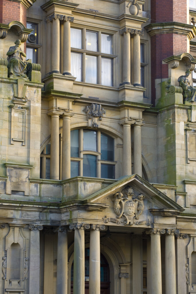 England, Tyne and Wear, Newcastle Upon Tyne. Architectural details of the Armstrong Building, part of the Newcastle University Campus. Competed in 1906, the two stone statues were included to represent science and the arts.