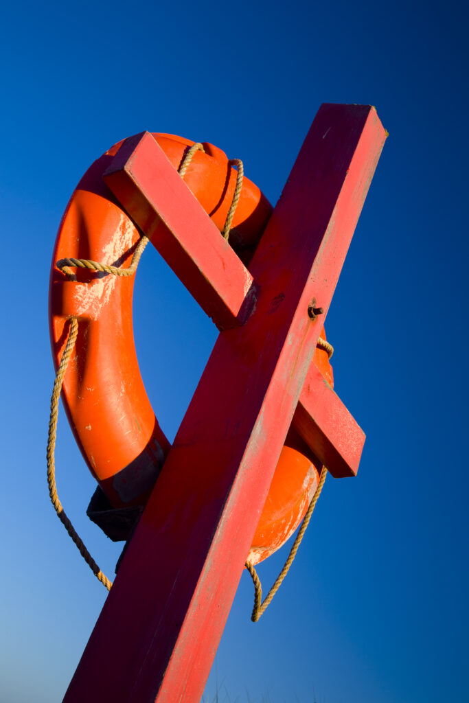 England, Northumberland, Heritage Coast. Red Life Ring against a blue sky, photographed near Bamburgh on the heritage coast.