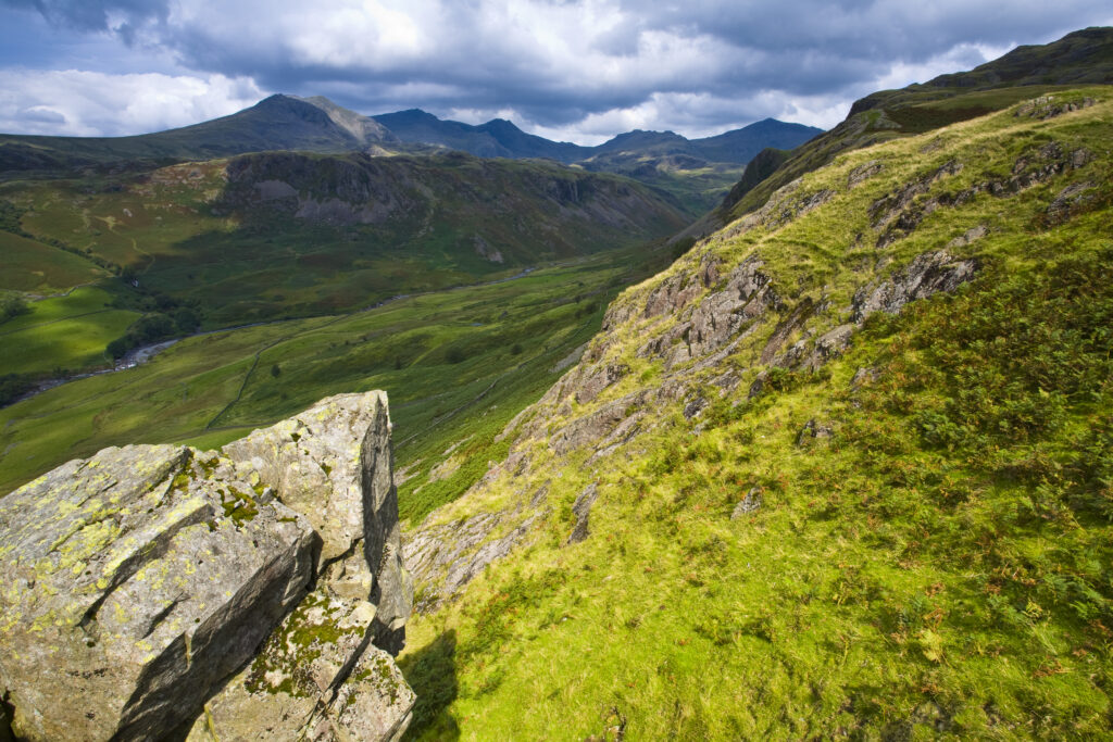 England, Cumbria, Lake District National Park. Looking along the route of the River Esk from the Hardknott Castle Roman Fort, as storms clouds gather above the countrys’ highest peak, Scafell Pike at 3205ft.