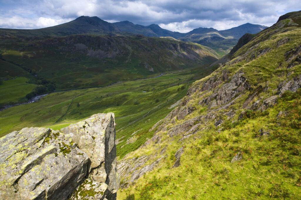 England, Cumbria, Lake District National Park. Looking along the route of the River Esk from the Hardknott Castle Roman Fort, as storms clouds gather above the countrys’ highest peak, Scafell Pike at 3205ft.
