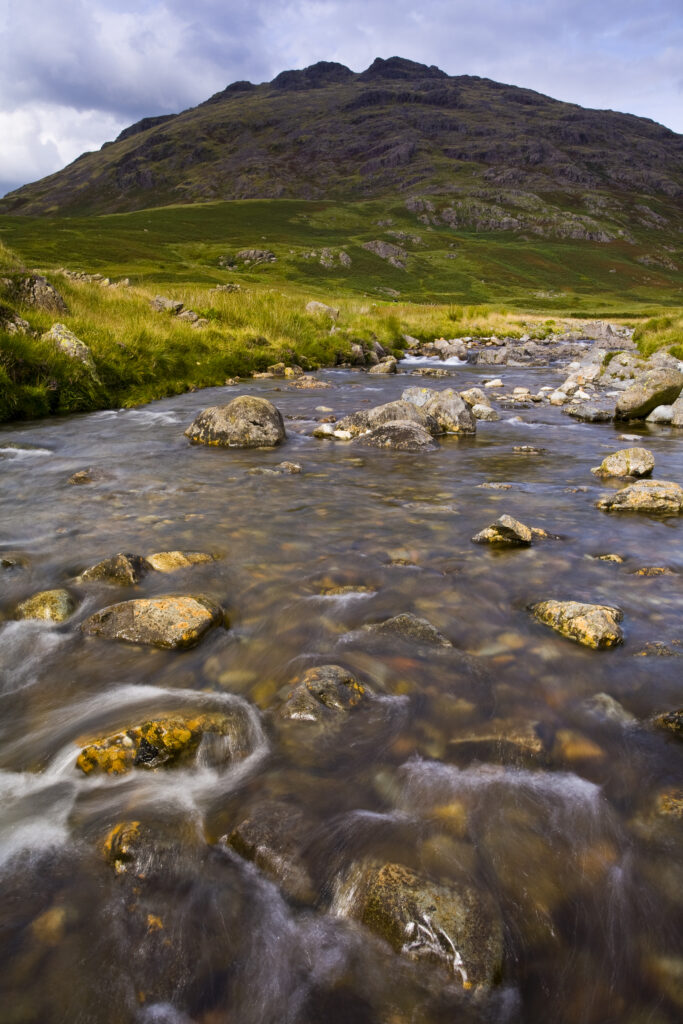 England, Cumbria, Lake District National Park. River Duddon and storm clouds above the Little Stand and Ulpha Fell.