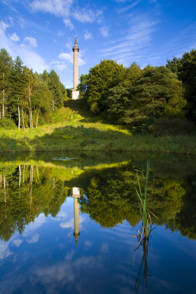 England, Tyne and Wear, Gibside. The column of liberty reflected in a pool forming part of the 18th-century landscaped 'forest' garden.