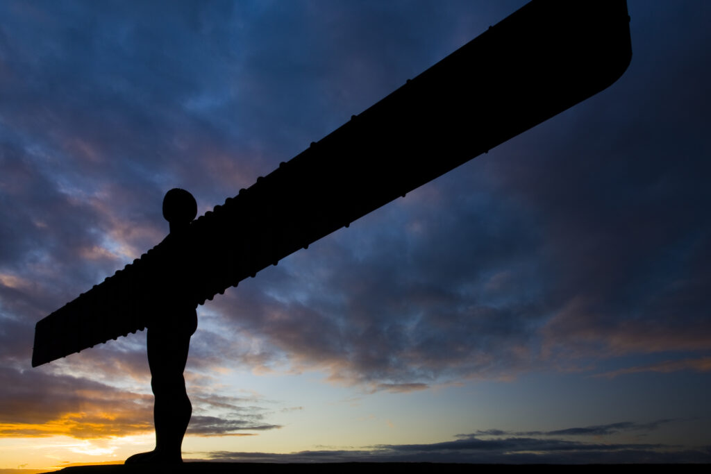 England, Tyne and Wear, Gateshead. The iconic Angel of the North statue silhouetted against an atmospheric sky. The 'Angel', built on a a former colliery pit head bath site, is one of the worlds most viewed work of art with over 33 million viewers each year.