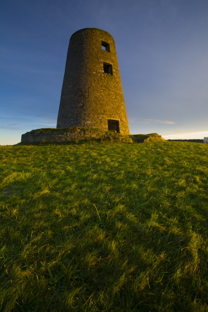 England, Tyne & Wear, Cleadon Hills. The rising sun spotlights the old mill in Windmill Field, located within the Cleadon Hills Local Nature Reserve.