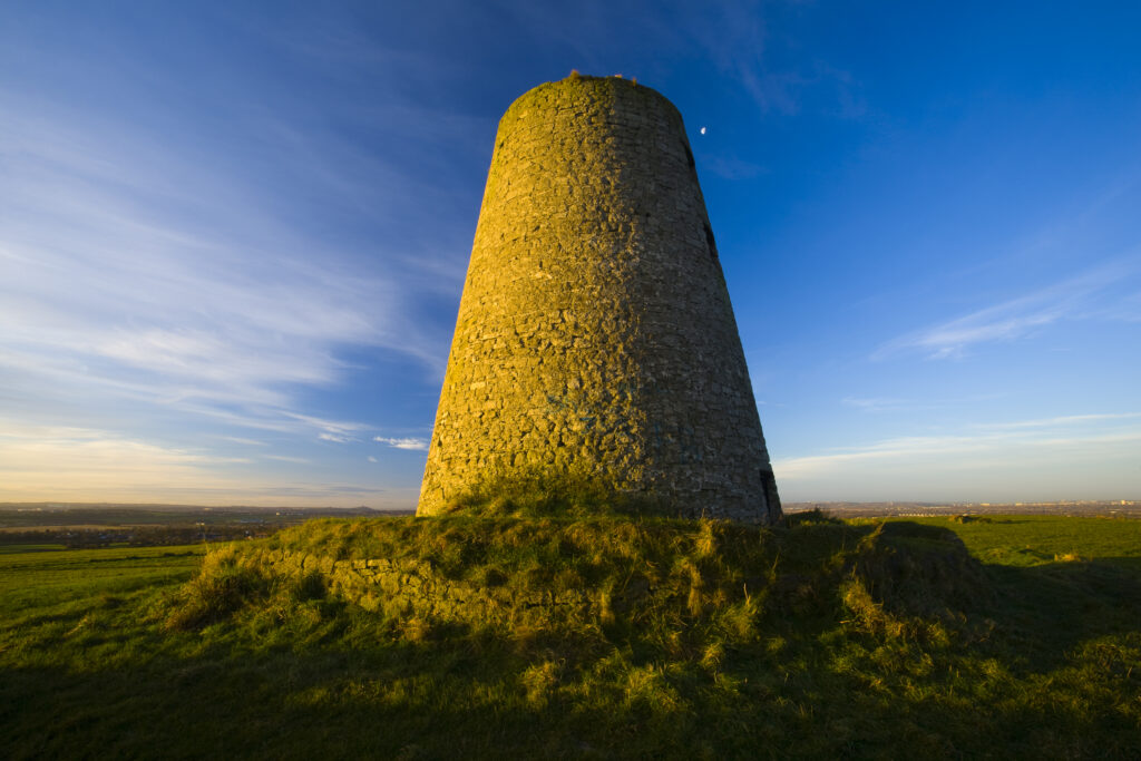 England, Tyne & Wear, Cleadon Hills. The rising sun spotlights the old mill in Windmill Field, located within the Cleadon Hills Local Nature Reserve.