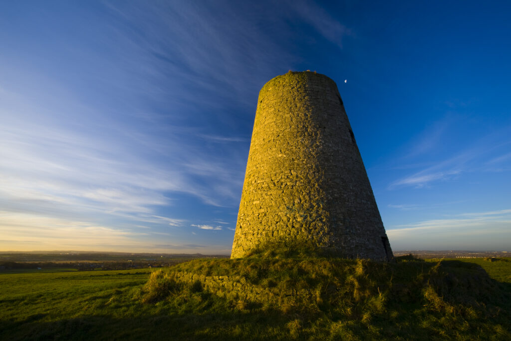 England, Tyne & Wear, Cleadon Hills. The rising sun spotlights the old mill in Windmill Field, located within the Cleadon Hills Local Nature Reserve.