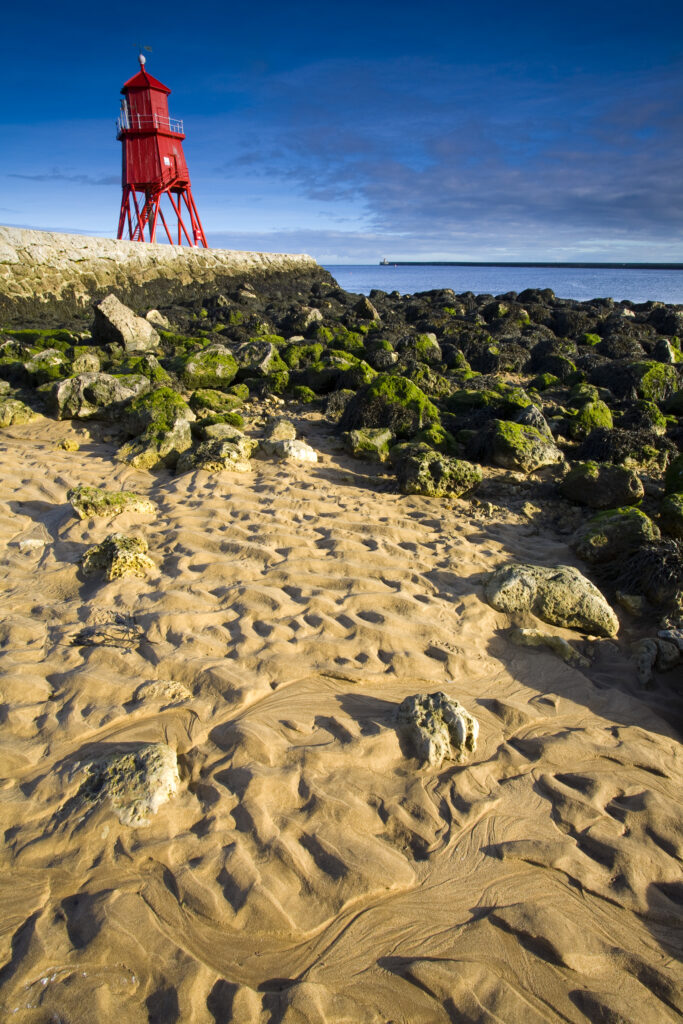 England, Tyne & Wear, South Shields. Little Haven Beach, looking towards the South Groyne Lighthouse.