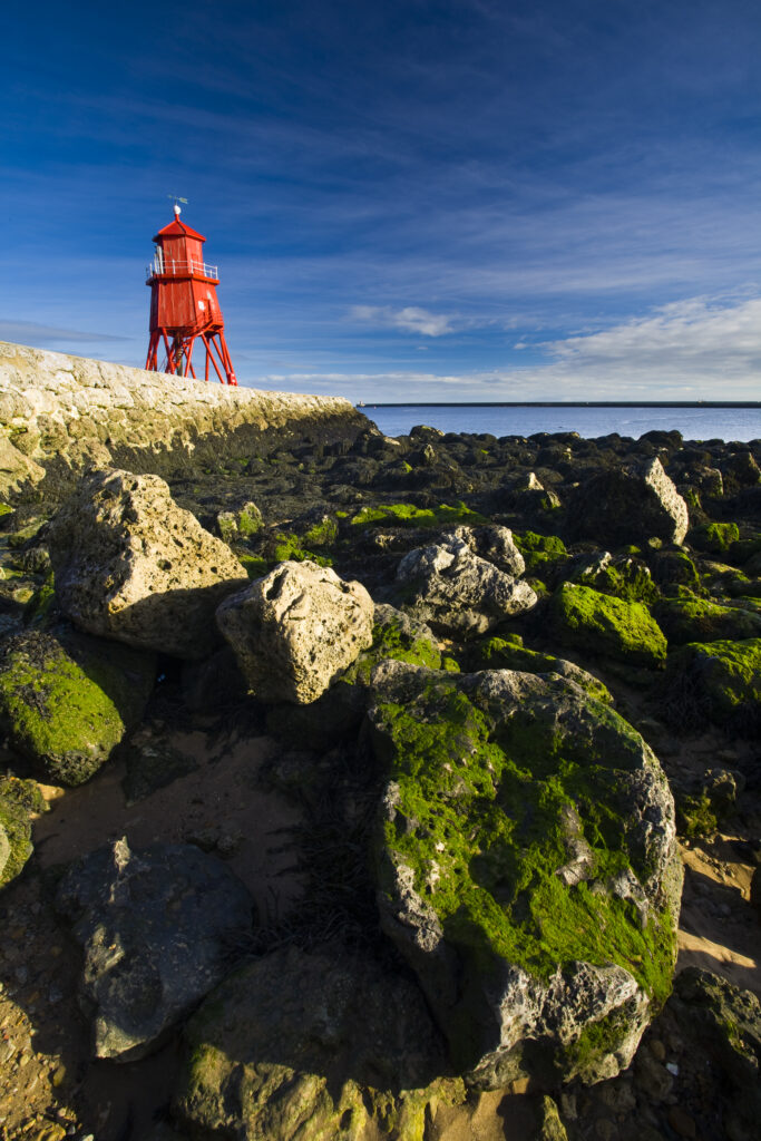 England, Tyne & Wear, South Shields. Little Haven Beach, looking towards the South Groyne Lighthouse.