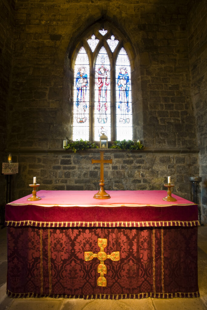 England, Tyne and Wear, St Pauls Monastery and church. Altar, Altar Cross and Candlesticks in the Sanctuary at St Pauls church near Jarrow, a 7th Century monastery founded in AD 681.