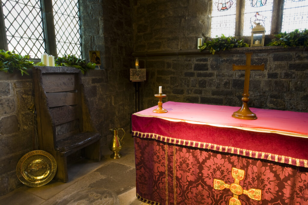 England, Tyne and Wear, St Pauls Monastery and church. Bedes Chair, Altar, Altar Cross and Candlesticks in the Sanctuary at St Pauls church near Jarrow, a 7th Century monastery founded in AD 681.