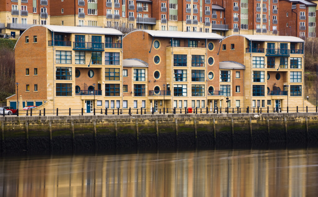 England, Tyne and Wear, Newcastle Upon Tyne. New apartments and penthouses built on the Newcastle Quayside, reflected in the still waters of the Tyne.