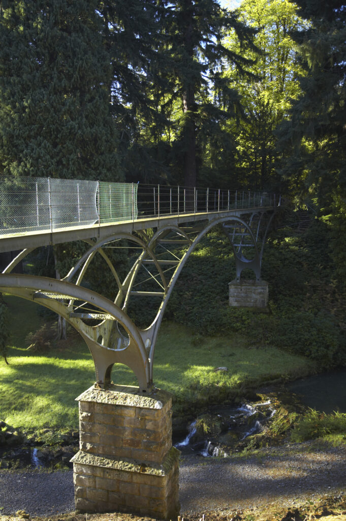 England, Northumberland, Cragside Gardens & Estate. A bridge crossing over a small burn and woodland within the Cragside estate (National Trust)
