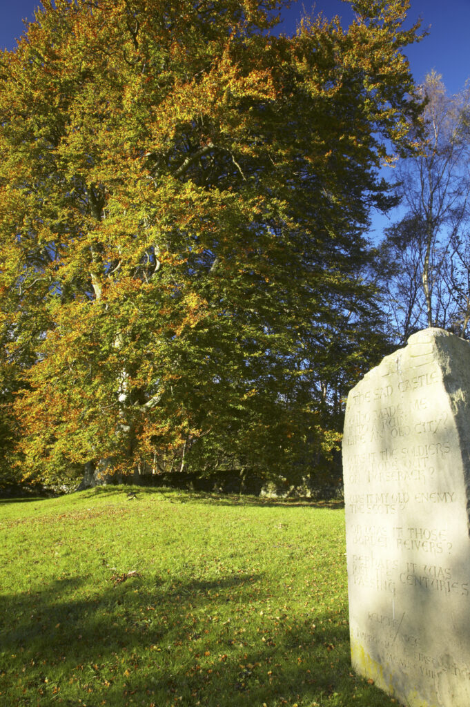England, Northumberland, Northumberland National Park. Stone monument and autumn colours near the remains of Harbottle Castle in Coquetdale