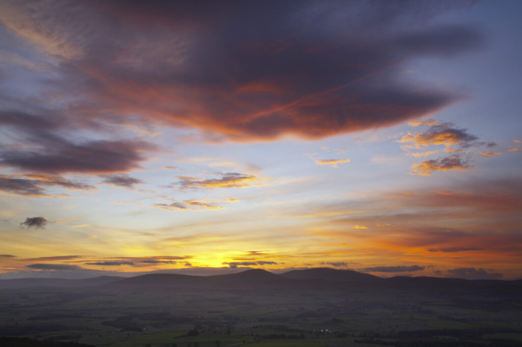 England, Northumberland, Northumberland National Park. A spectacular sunset over the Cheviot Hills, viewed from Ros Castle (National Trust)
