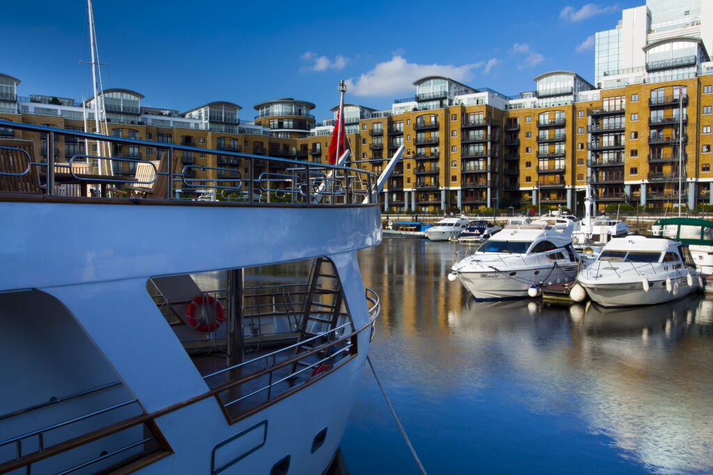 England, Greater London, London Borough of Tower Hamlets. Boats moored in the St Katharine Docks, a popular housing and leisure complex in the area known as the Docklands on the north bank of the River Thames near the London Tower Bridge.
