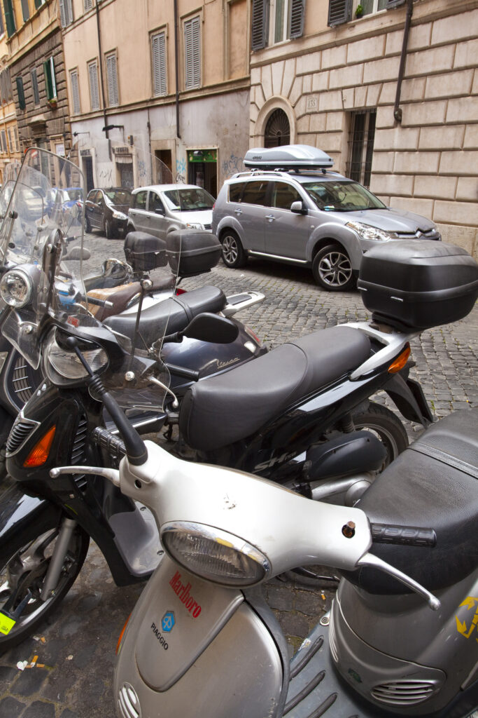 Italy, Lazio, Rome. Mopeds and scooters parked outside a typical Rome restaurant in the city of Rome.