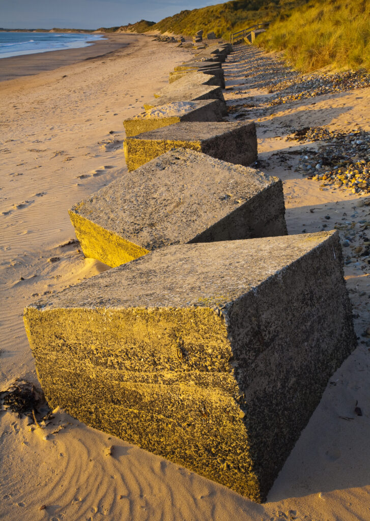 England, Northumberland, Druridge Bay. World War Two anti-tank blocks defending the picturesque beach at Druridge Bay.